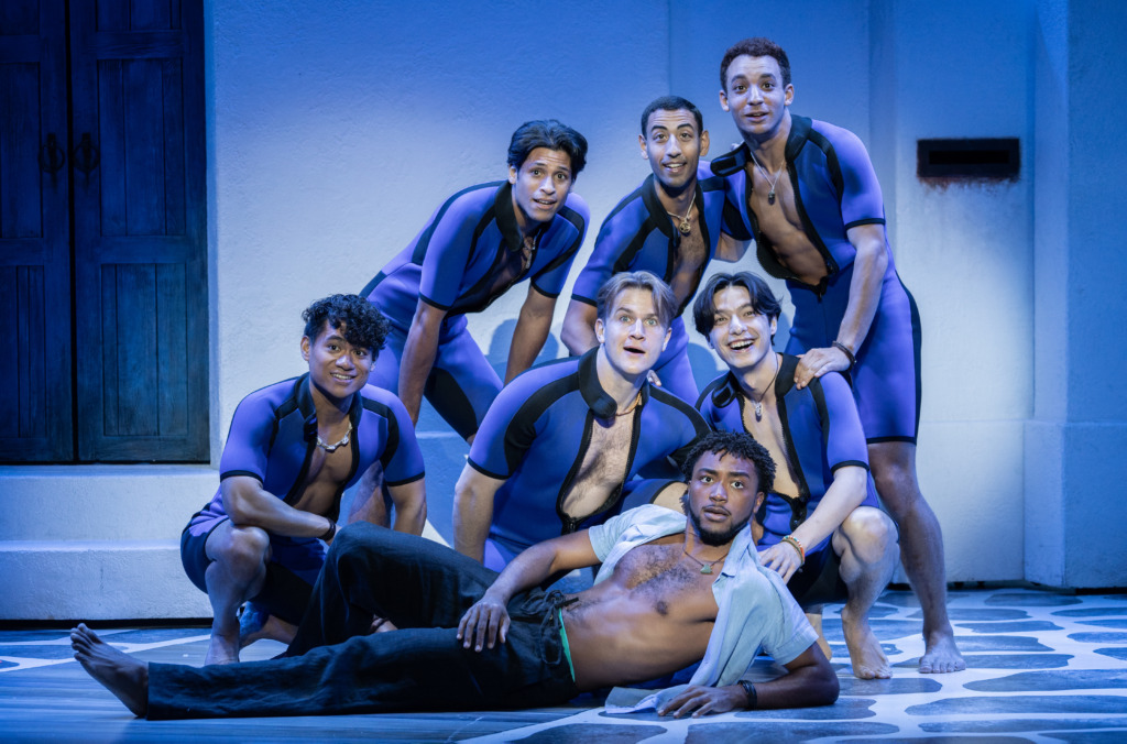 Grant Reynolds (laying center) as Sky with the company of Mamma Mia 25th Anniversary Tour 📷 Joan Marcus