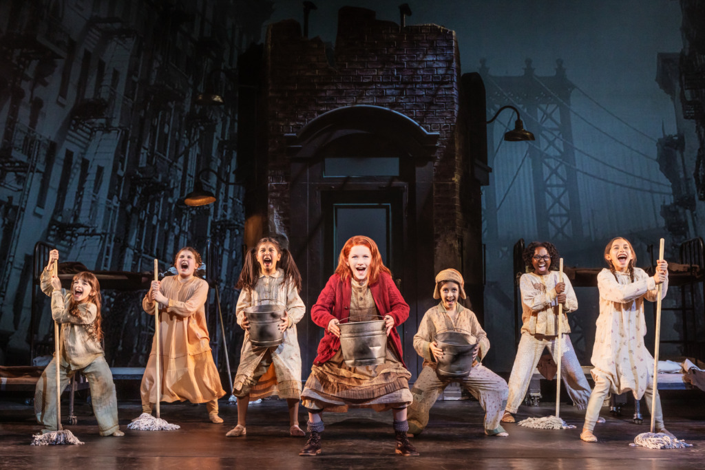 Hazel Vogel (center) as Annie and the company of Annie 📷 Matthew Murphy